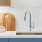 a kitchen sink with cutting boards and small plant