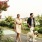 A woman and man walking with a yellow Labrador